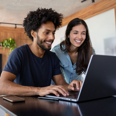 man and woman preparing taxes in front of laptop