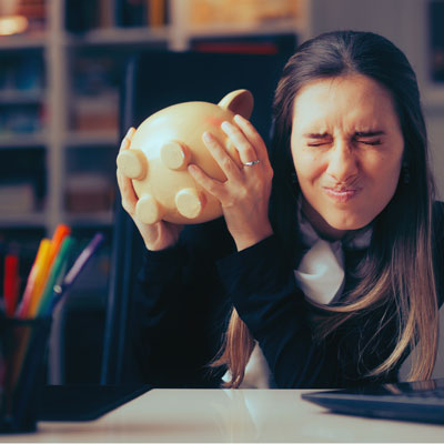 woman shaking empty piggy bank